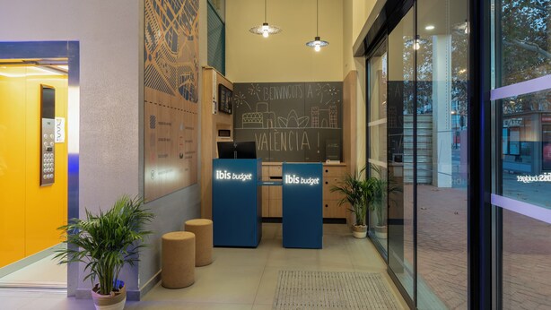 A reception area with a chalkboard displaying 'VALENCIA!' and two 'ibis budget' counters. - Ibis Budget Valencia Centro Puerto (Valencia)