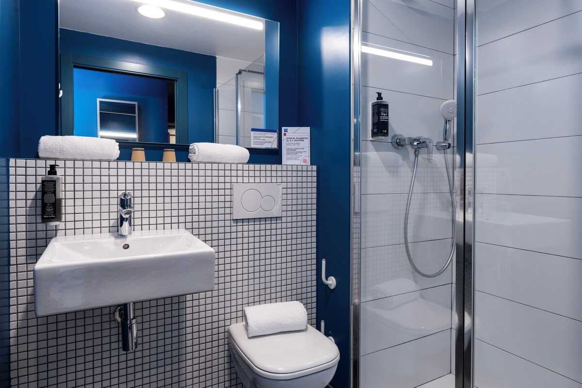A bathroom with a white sink, a toilet, and a glass-enclosed shower.