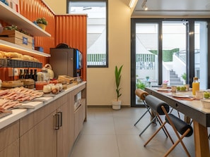 Een moderne keuken met een ontbijtbalk, houten kastjes en uitzicht op het balkon.