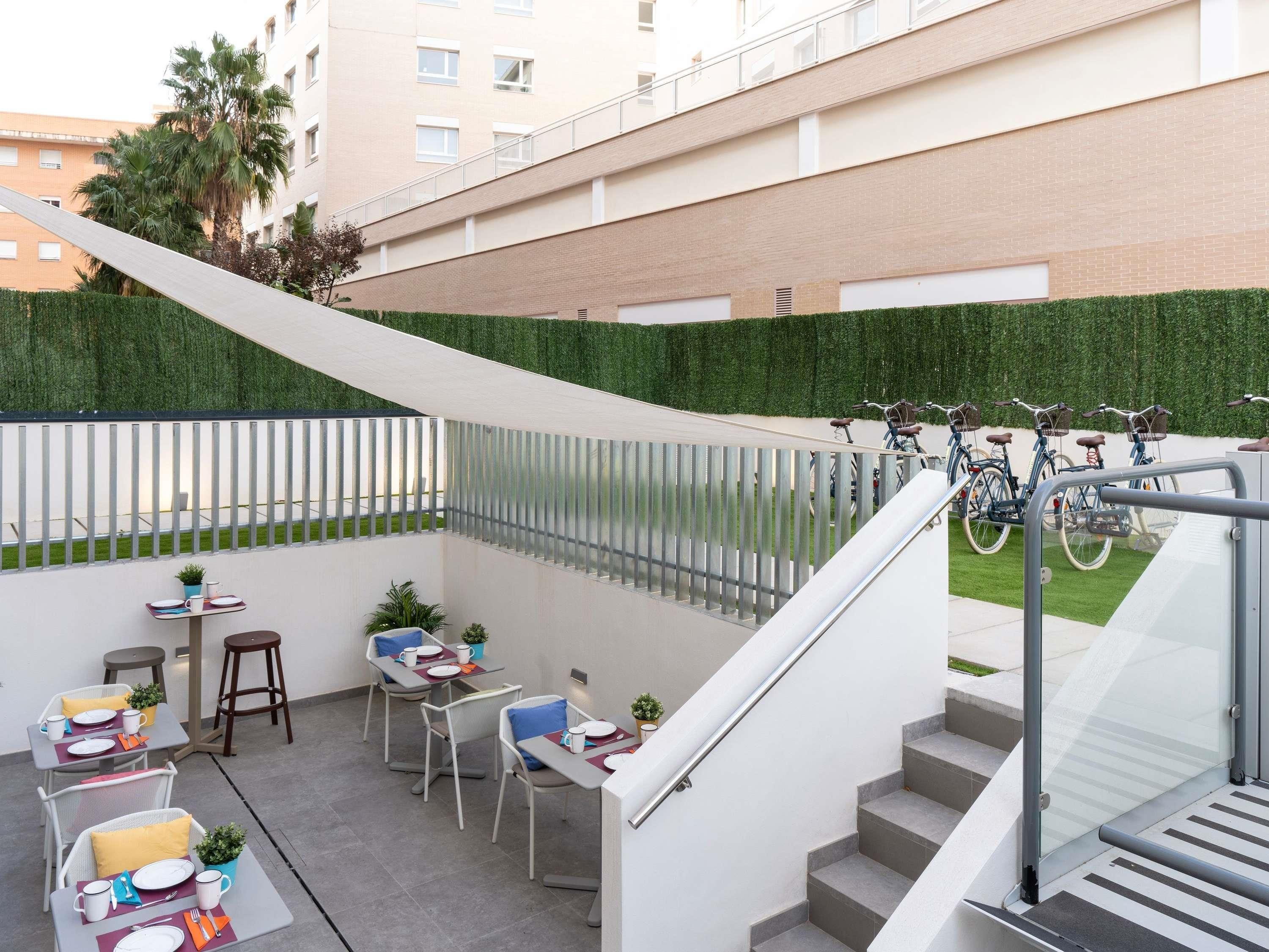 Un patio moderno al aire libre con escaleras, un espacio de estar y bicicletas.