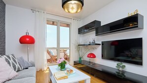 Un salon moderne comprenant un canapé, une table basse, un téléviseur et des objets de décoration.