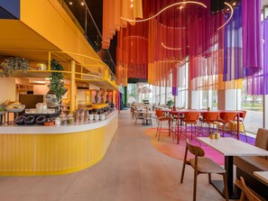 En modern restaurang med en böjd bardisk, sittområde och stora fönster.
