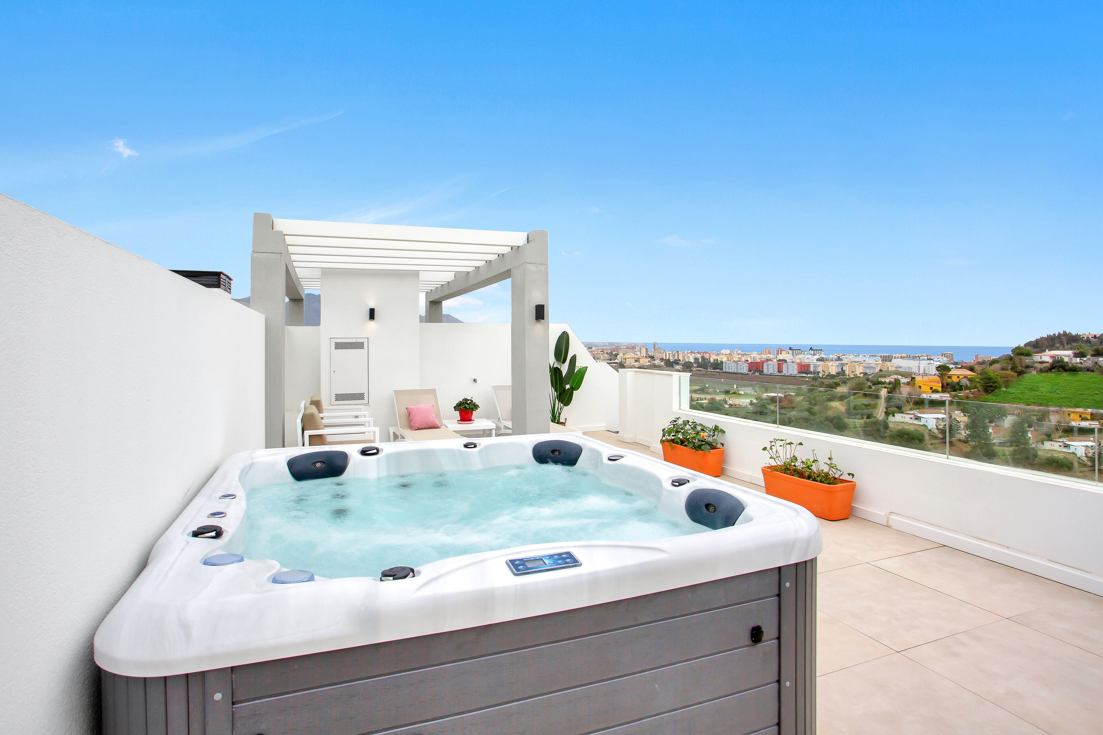 Een bubbelbad op een balkon met uitzicht op de stad.