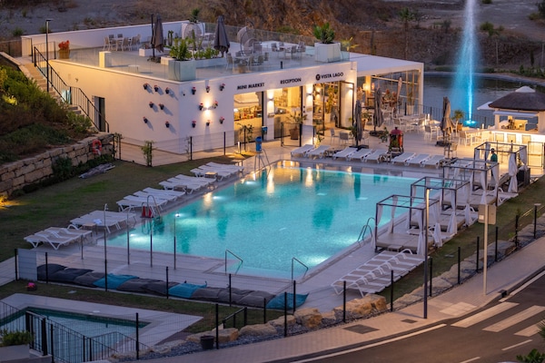 Una piscina al aire libre, una piscina climatizada, sombrillas, tumbonas