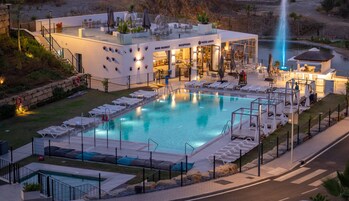 Una piscina al aire libre, una piscina climatizada, sombrillas