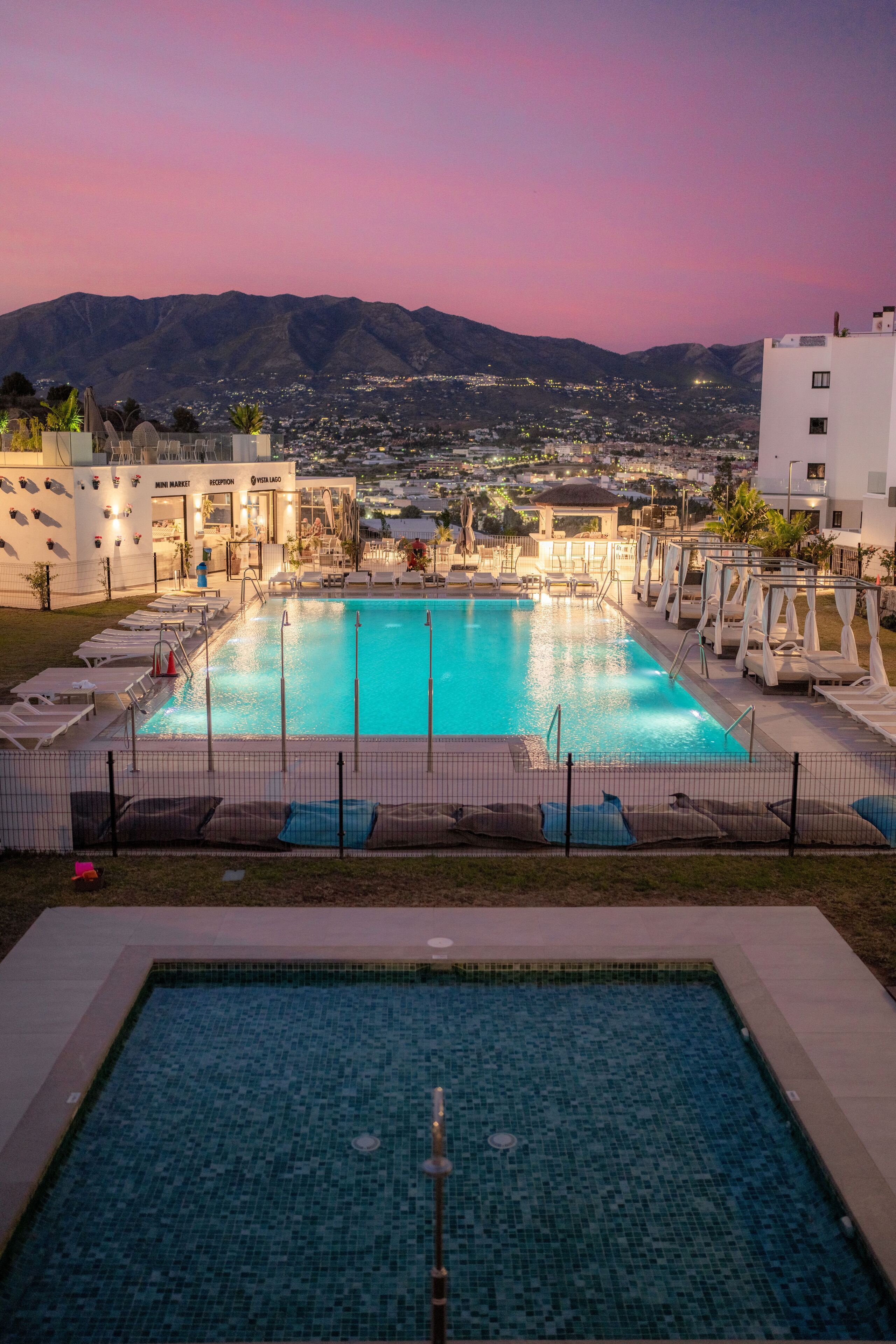 Una piscina al aire libre, una piscina climatizada, sombrillas