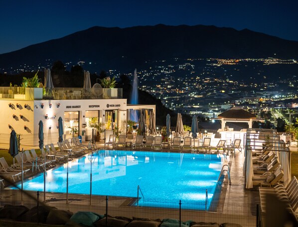 Outdoor pool, a heated pool, open 10:00 AM to 10:00 PM, pool umbrellas