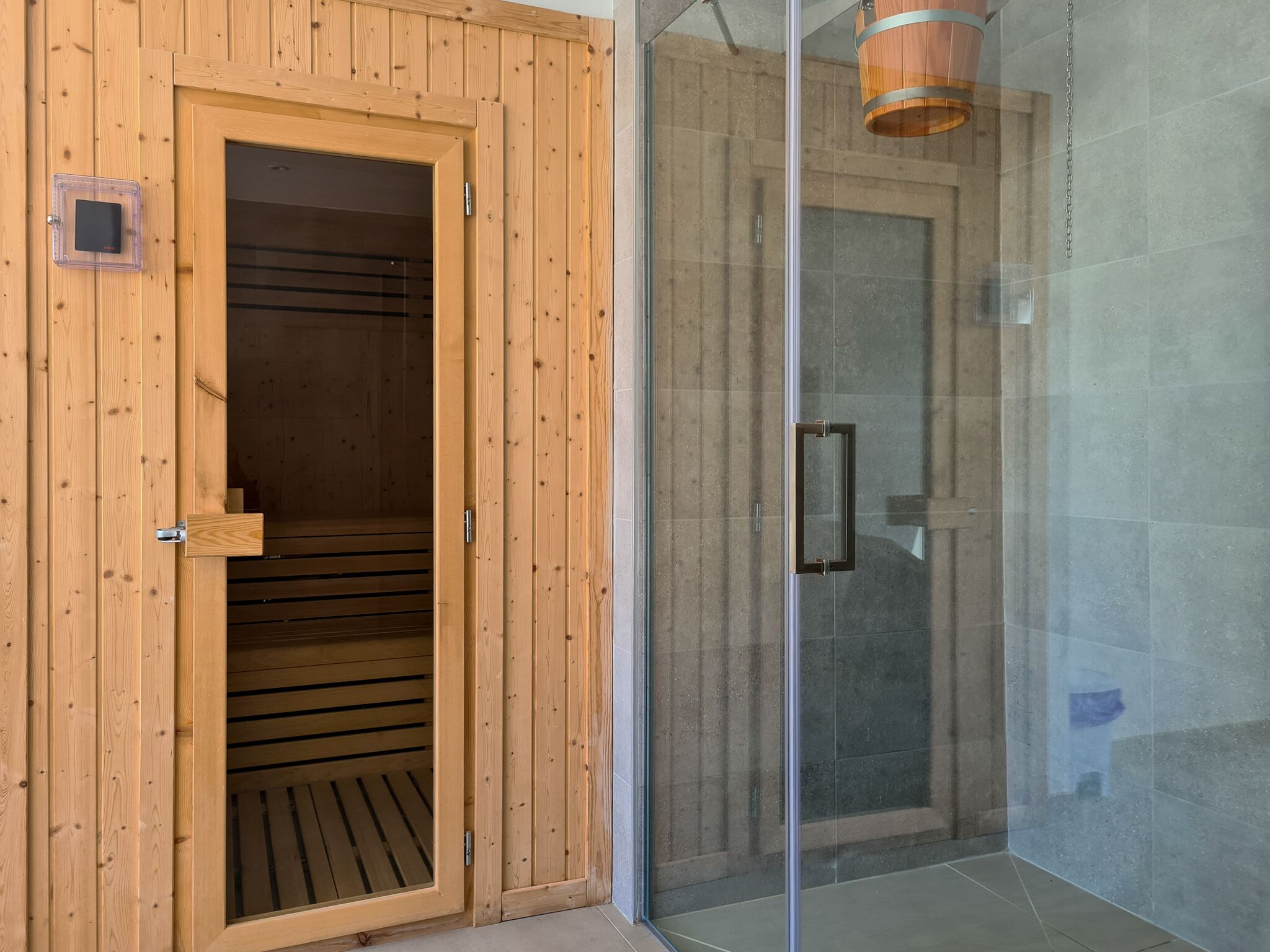 Ein Sauna-Raum mit Holzwänden und einer Glastür.