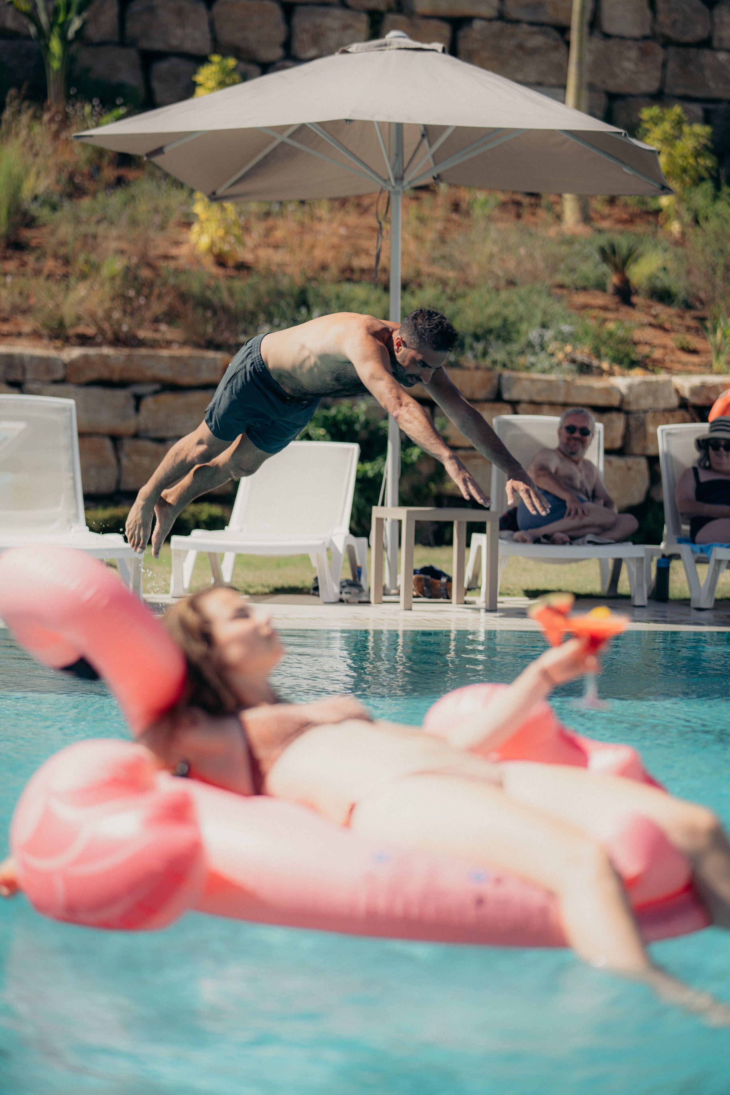 Una piscina con sillas de descanso y una sombrilla.