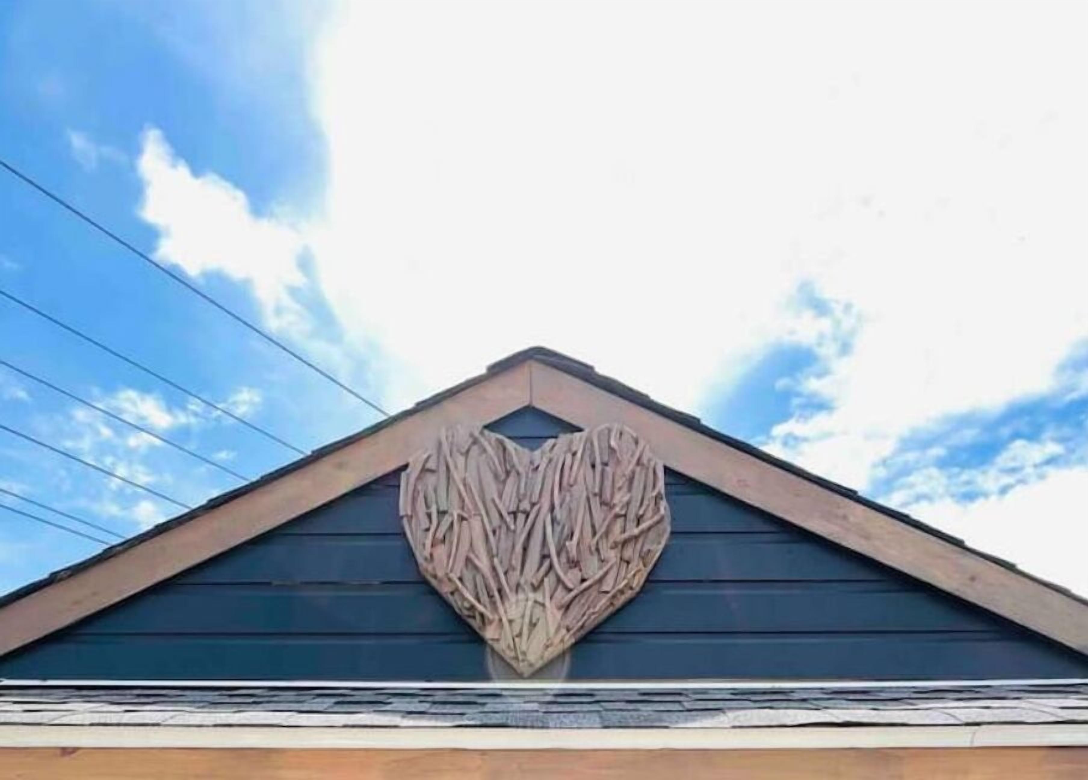 A building with a triangular roof and a heart-shaped wooden decoration on the gable.