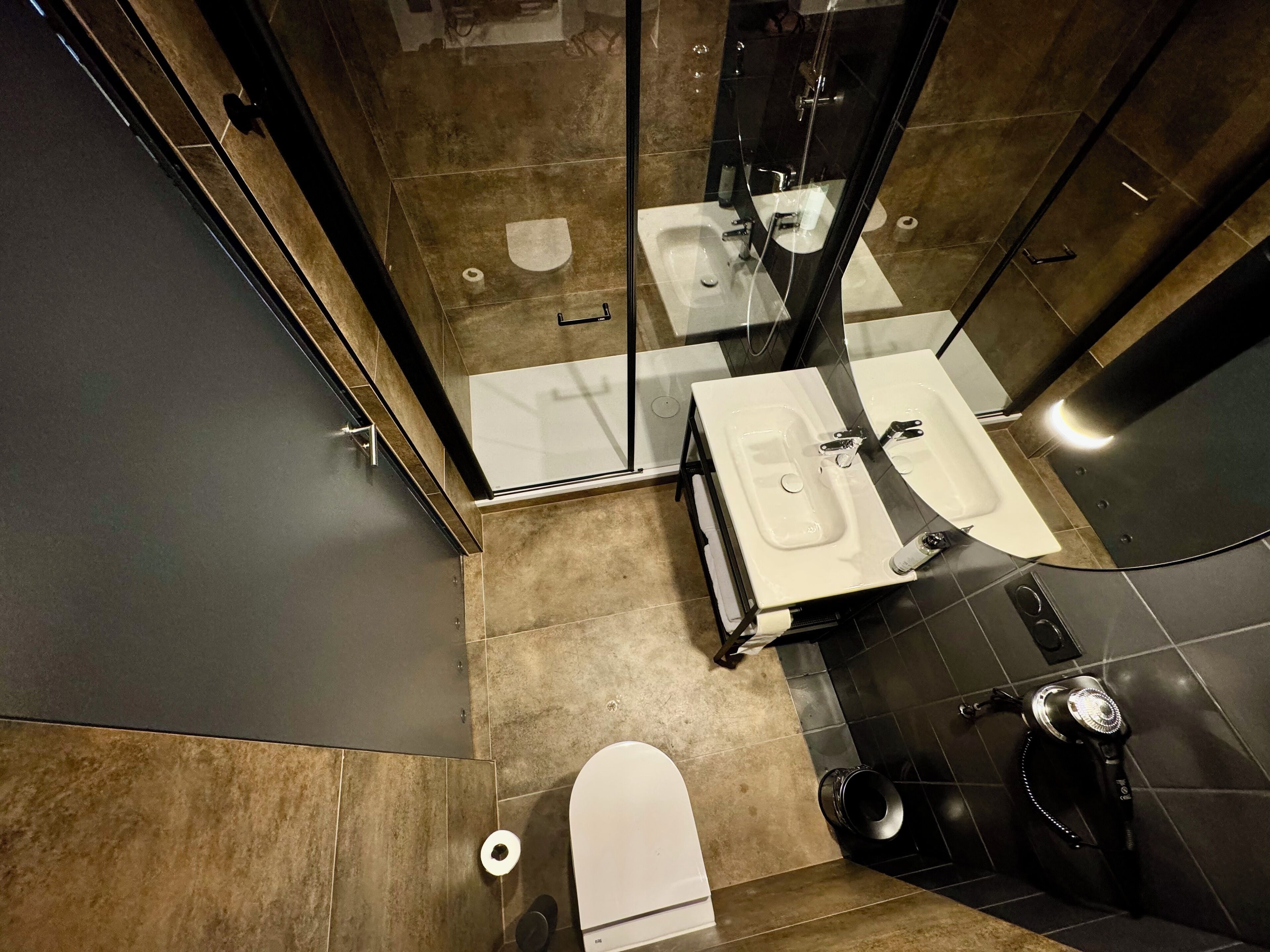 A modern bathroom with a toilet, sink, and shower area.