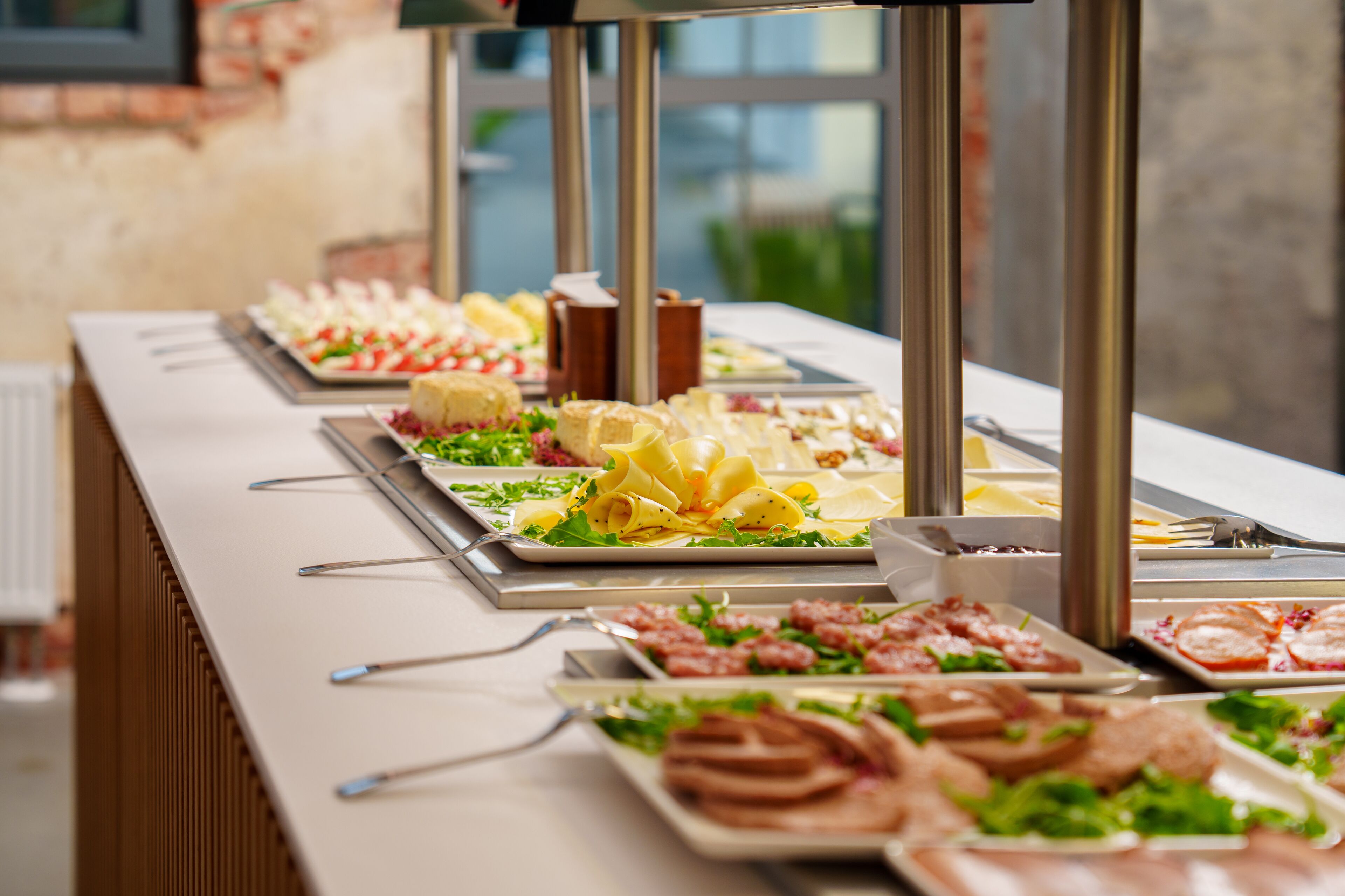 Un buffet con diverse opzioni tra cui insalate, carni e dolci.