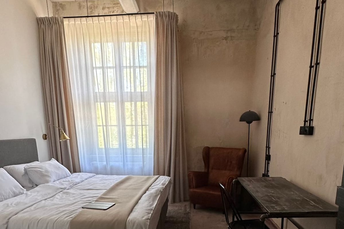 Quarto com uma cama, uma escrivaninha e uma cadeira.