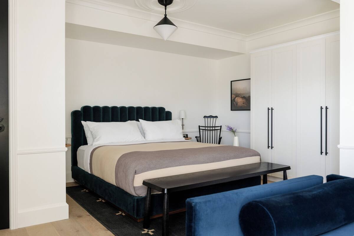 Ein Schlafzimmer mit Bett, Nachttisch und Stuhl.