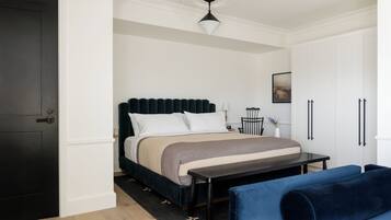 A bedroom with a bed, bedside table, and a chair.