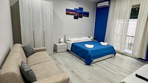 Une chambre moderne avec un grand lit, un canapé, un bureau et une armoire.