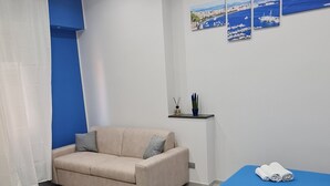 Une chambre à coucher moderne avec un lit, un canapé et une petite table.