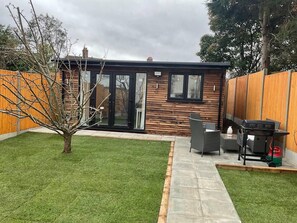 A modern house with a patio area, a small garden, and a barbecue setup. - Captivating 1-bed Studio in London (London)