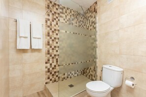 A bathroom with a shower, toilet, and two towels hanging on the wall. - Cortijo Mari Carmen - Three Bedroom Villa, Sleeps 6 (Nerja)