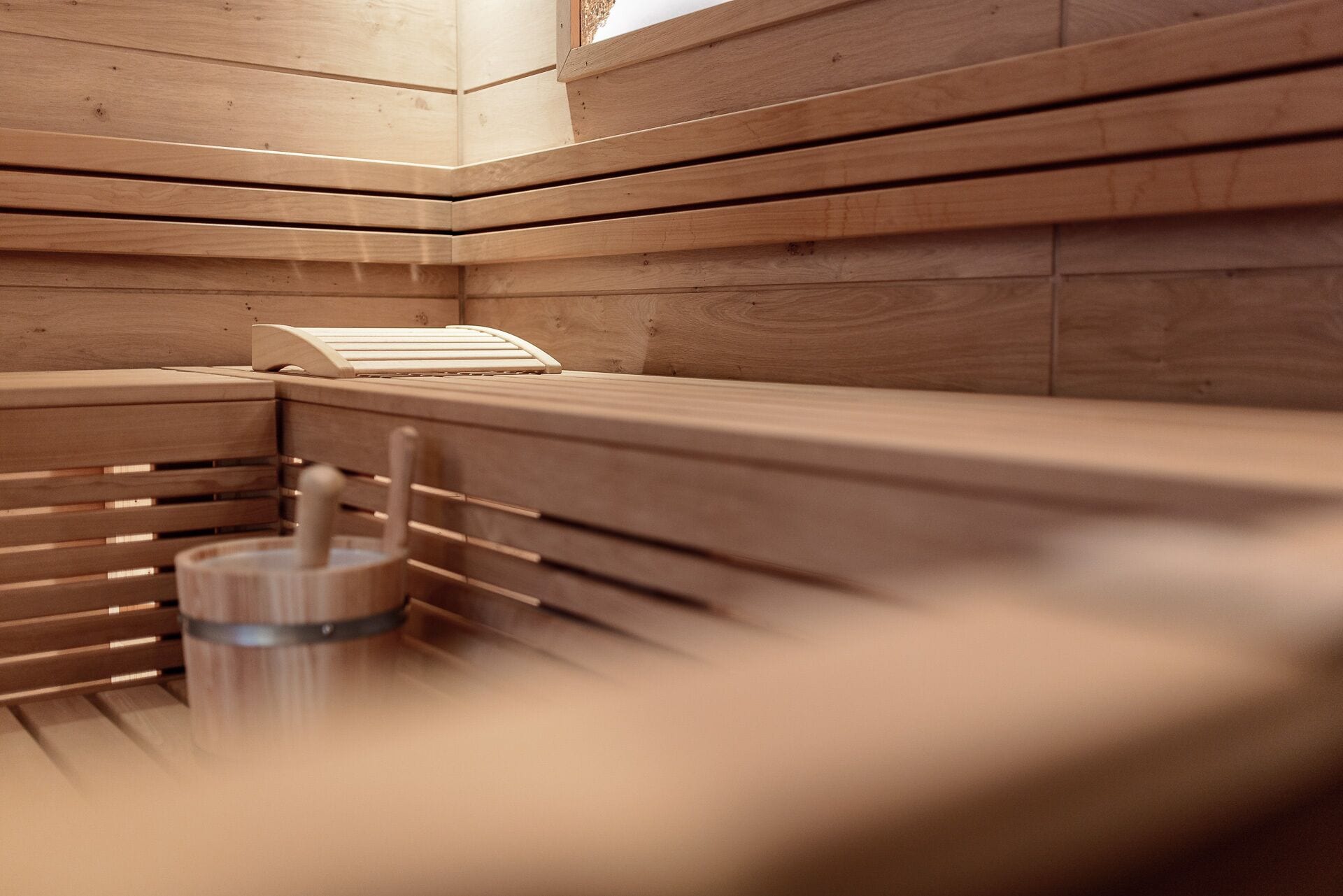 A sauna with wooden benches and a metal bench.