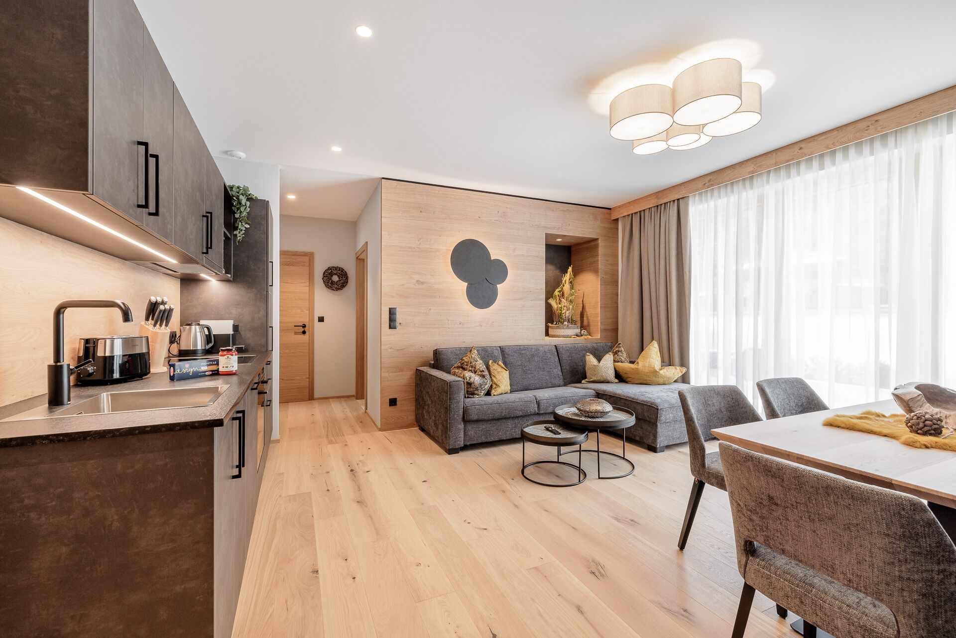 A modern apartment with a kitchen, dining area, and living room.