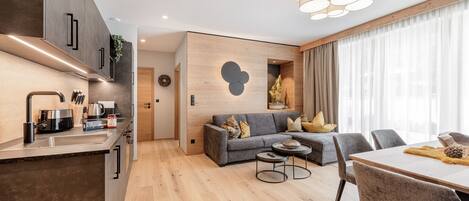 A modern apartment with a kitchen, dining area, and living room.