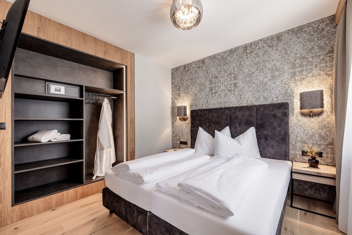 Ein modernes Hotelzimmer mit einem großen Bett, einem Schrank mit Regalen und einer Wandverzierung.