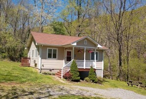 Situated in a wooded area, this house offers a peaceful retreat with a front porch and a small yard.