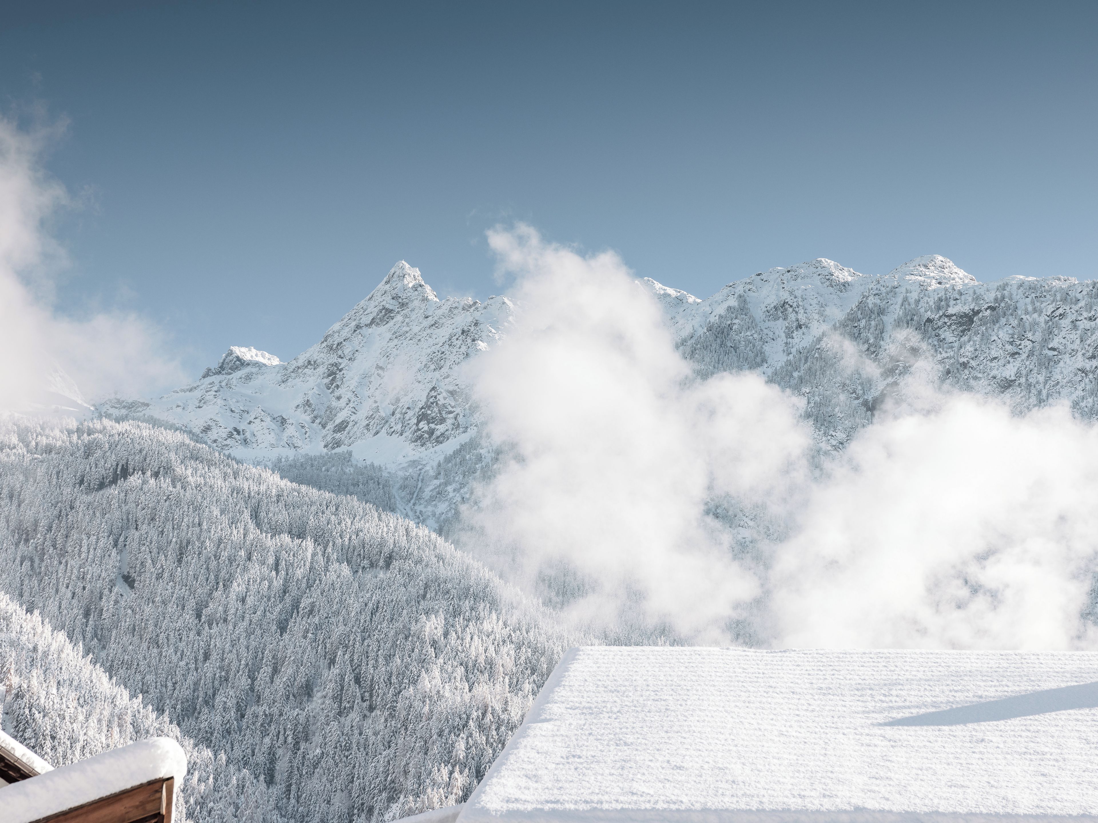 Un paysage de montagne enneigé, sous un ciel dégagé.