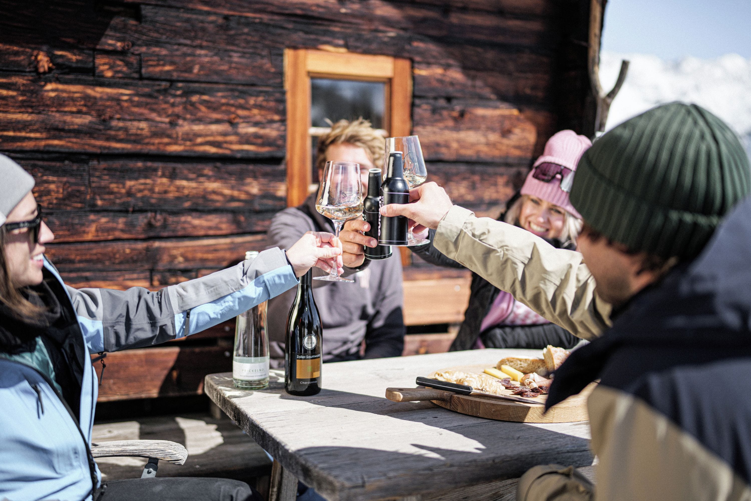Une cabane en bois avec un intérieur rustique, une table en bois sur laquelle sont disposés de la nourriture et des boissons, et un banc en bois.