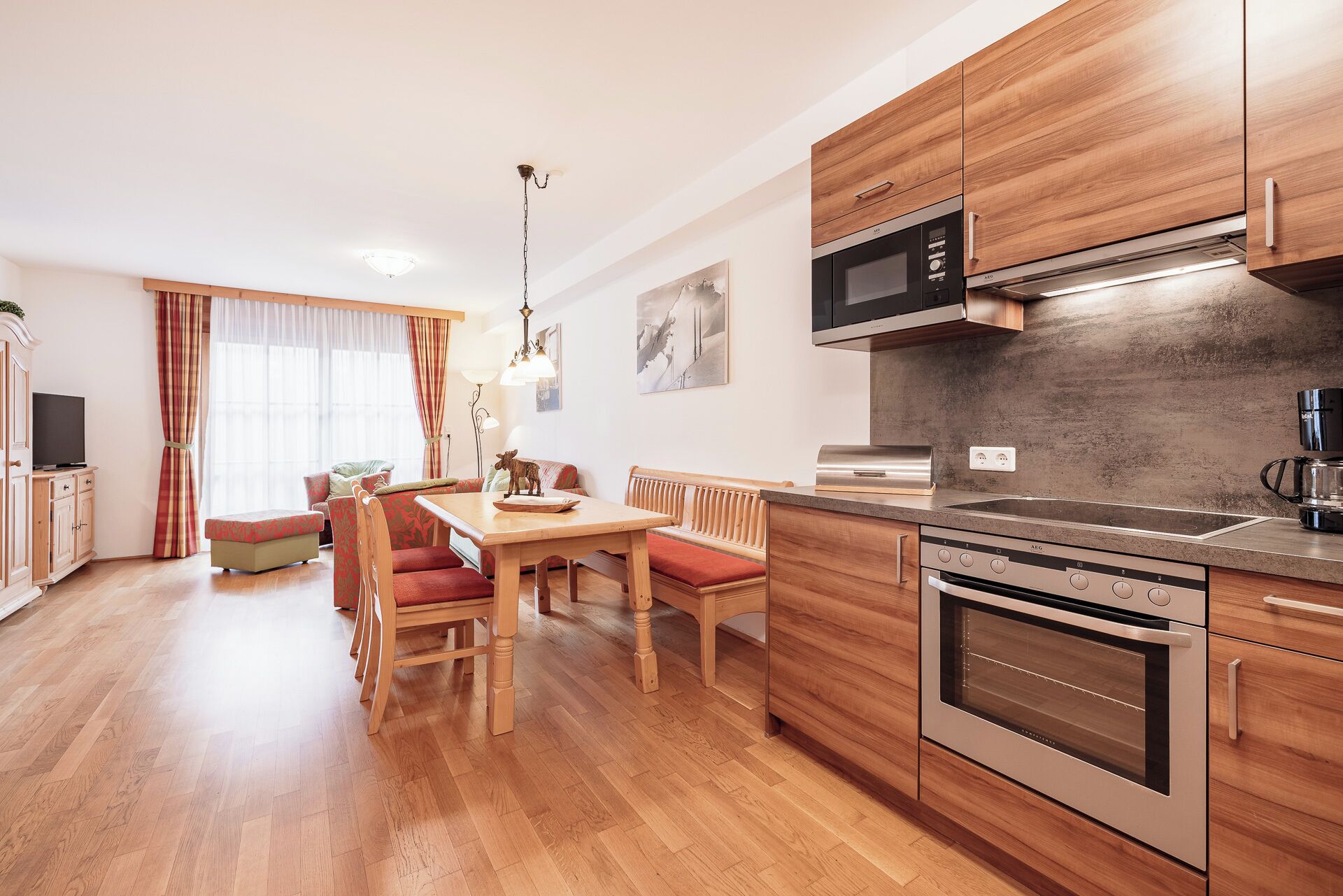 A modern kitchen with wooden cabinets, a built-in oven, and a microwave.