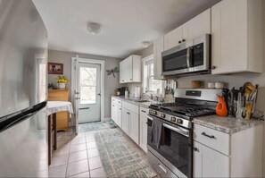 Enjoy cooking in this well-equipped kitchen with a stainless steel stove, microwave, and sink.