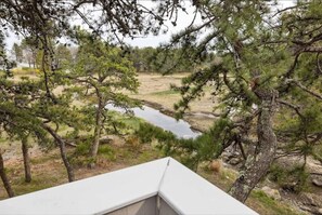 Enjoy breathtaking views of a serene natural landscape from this balcony.