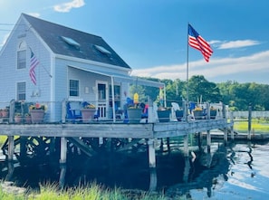 Une péniche avec un quai, des drapeaux américains et des plantes en pot.