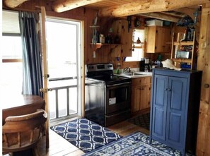 Une cuisine de taille réduite, avec des meubles de rangement en bois, une cuisinière et un évier.