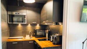 A compact kitchen with a microwave, toaster, sink, and a small refrigerator. - Aux Flots Bleus,  avec balcon et vue sur mer (Trouville-sur-Mer)