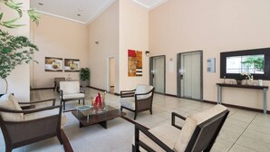 A spacious lobby with comfortable seating, a reception desk, and a television. - Vossa Bossa Pinheiros (São Paulo)