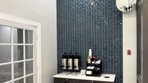 A bathroom with a white door, a mirror, and a vanity with a black cabinet and drawers. - Studio 6 Nacogdoches, Tx – Sfa University (Nacogdoches)