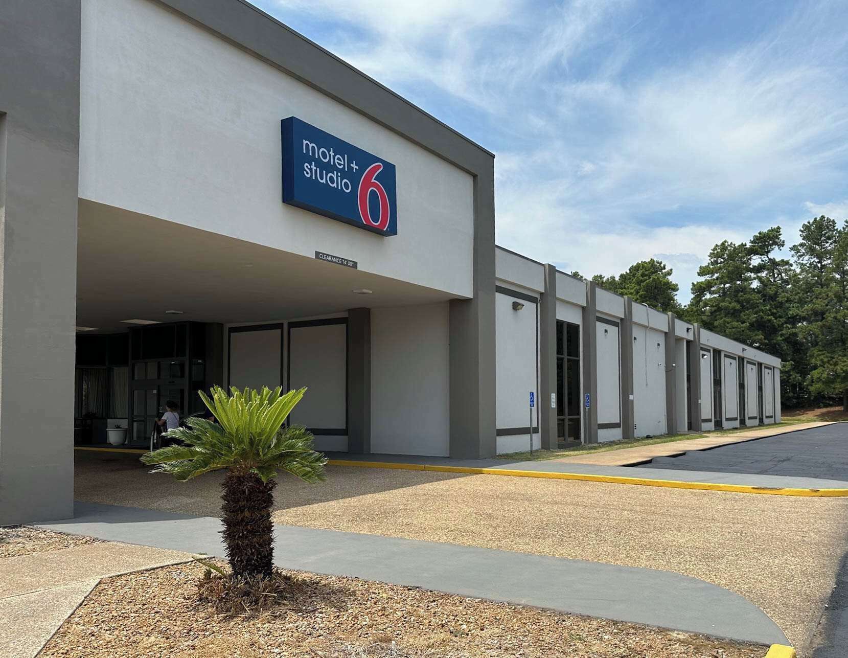 Un motel moderne avec une enseigne indiquant « motel + studio 6 » et une entrée bien visible.