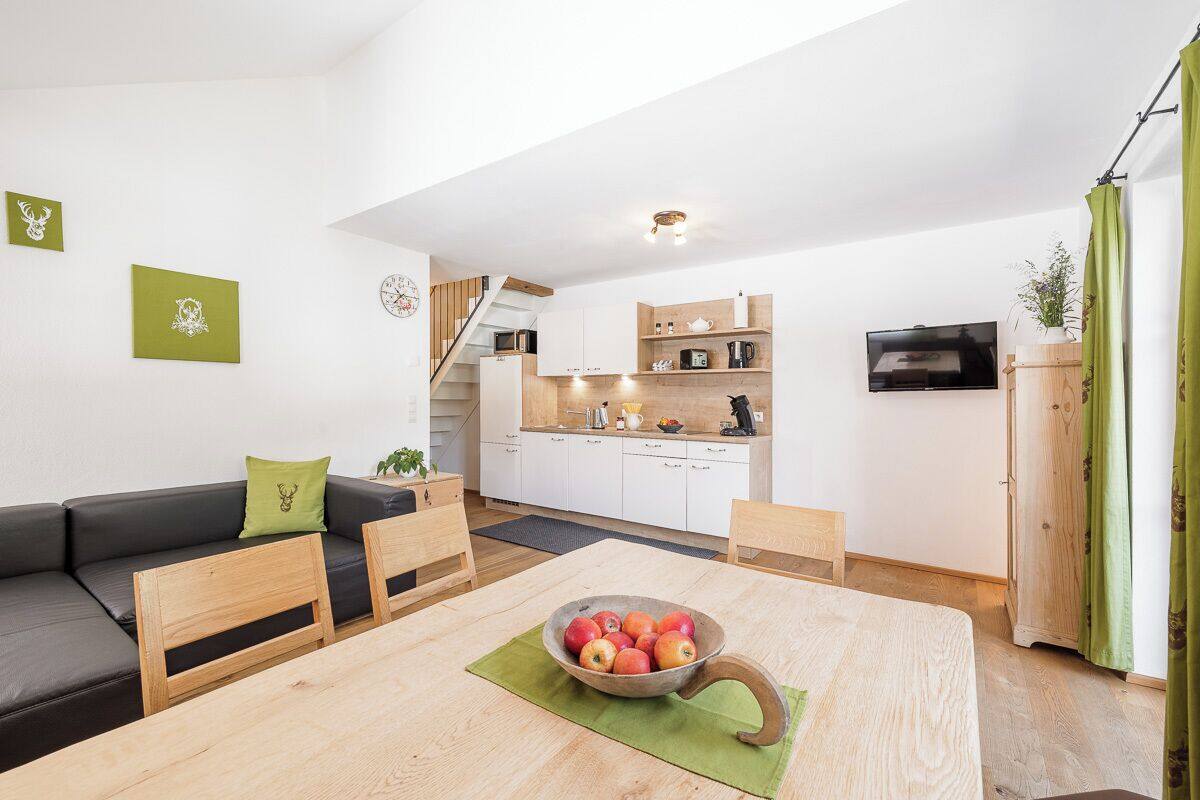 A modern apartment with a dining area, kitchen, and living space.