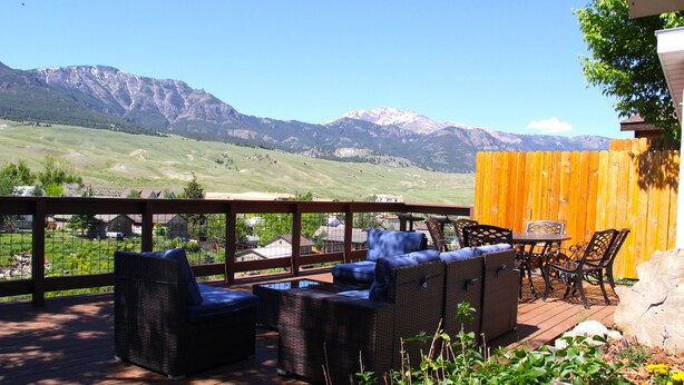 Une terrasse dotée de meubles en osier et offrant une vue sur les montagnes.