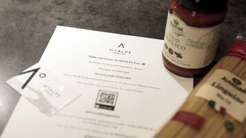 Un recibo de MYALPS Pure, una botella de salsa de tomate orgánica y una tarjeta con un código QR.