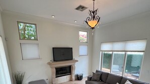 Un salon moderne avec un canapé d’angle, une cheminée et un téléviseur.
