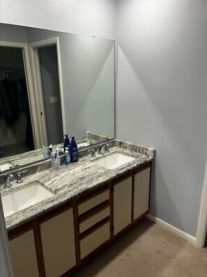 Une salle de bain avec deux lavabos, un grand miroir et des meubles en bois.