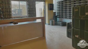 Un espace d’accueil avec un mur en pierre, un comptoir et un mur composé de boîtes de rangement.