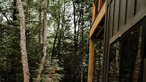 Eine Holzterrasse mit einem steinbelagten Weg, der zu einem Wald führt.