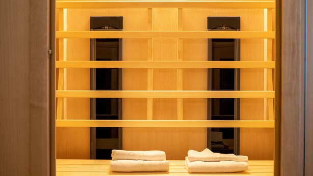 A wooden shelf unit with multiple compartments, some containing folded white towels. - Katzerhaus Ebensee (Ebensee)