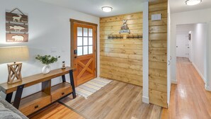 Een houten interieur met een bank, een deur en een bord aan de muur.