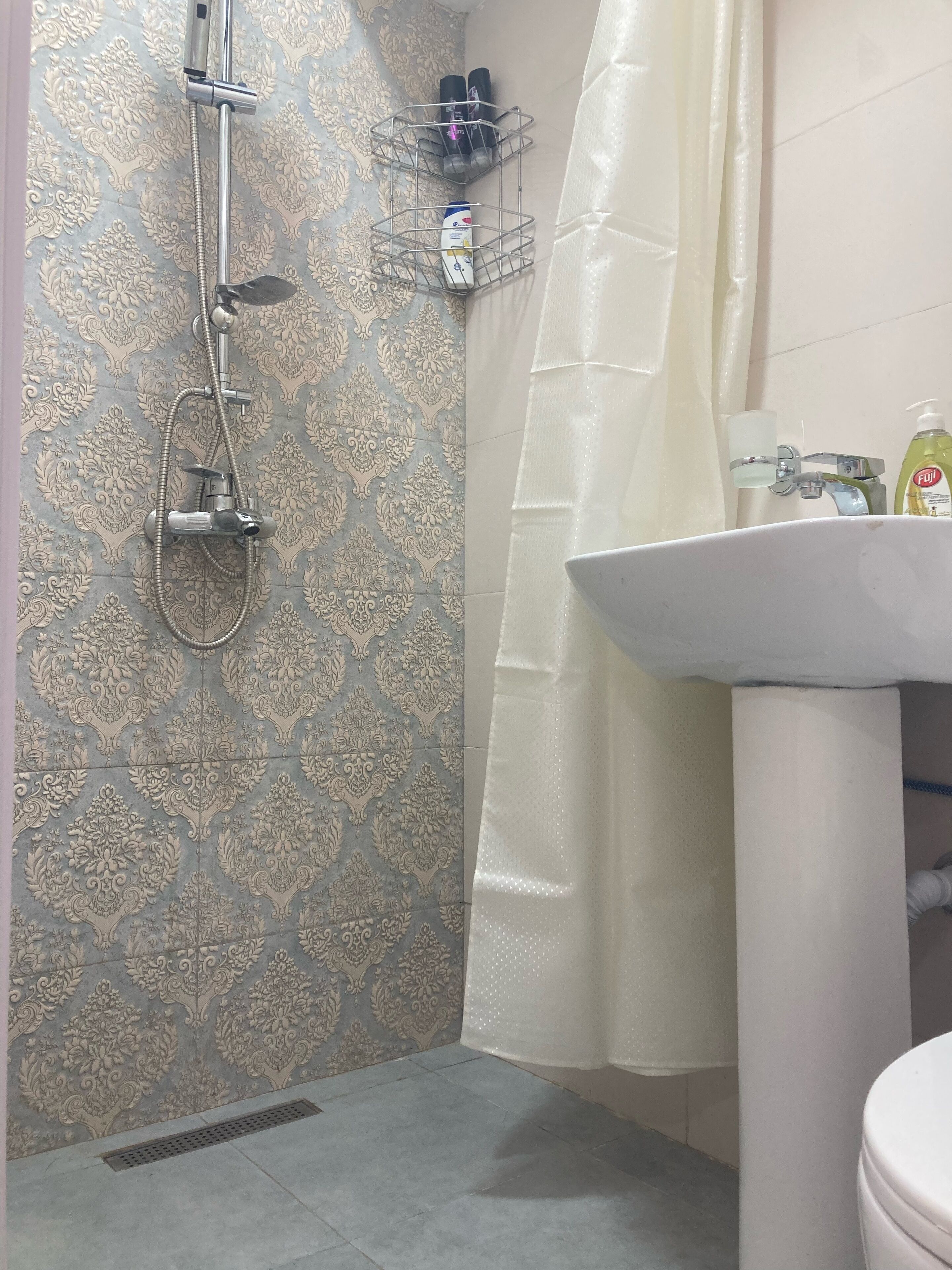 Un baño con ducha, lavabo e inodoro.