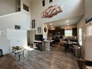 Relax in this spacious living area with a mezzanine level, featuring a sofa, TV, and dining space.